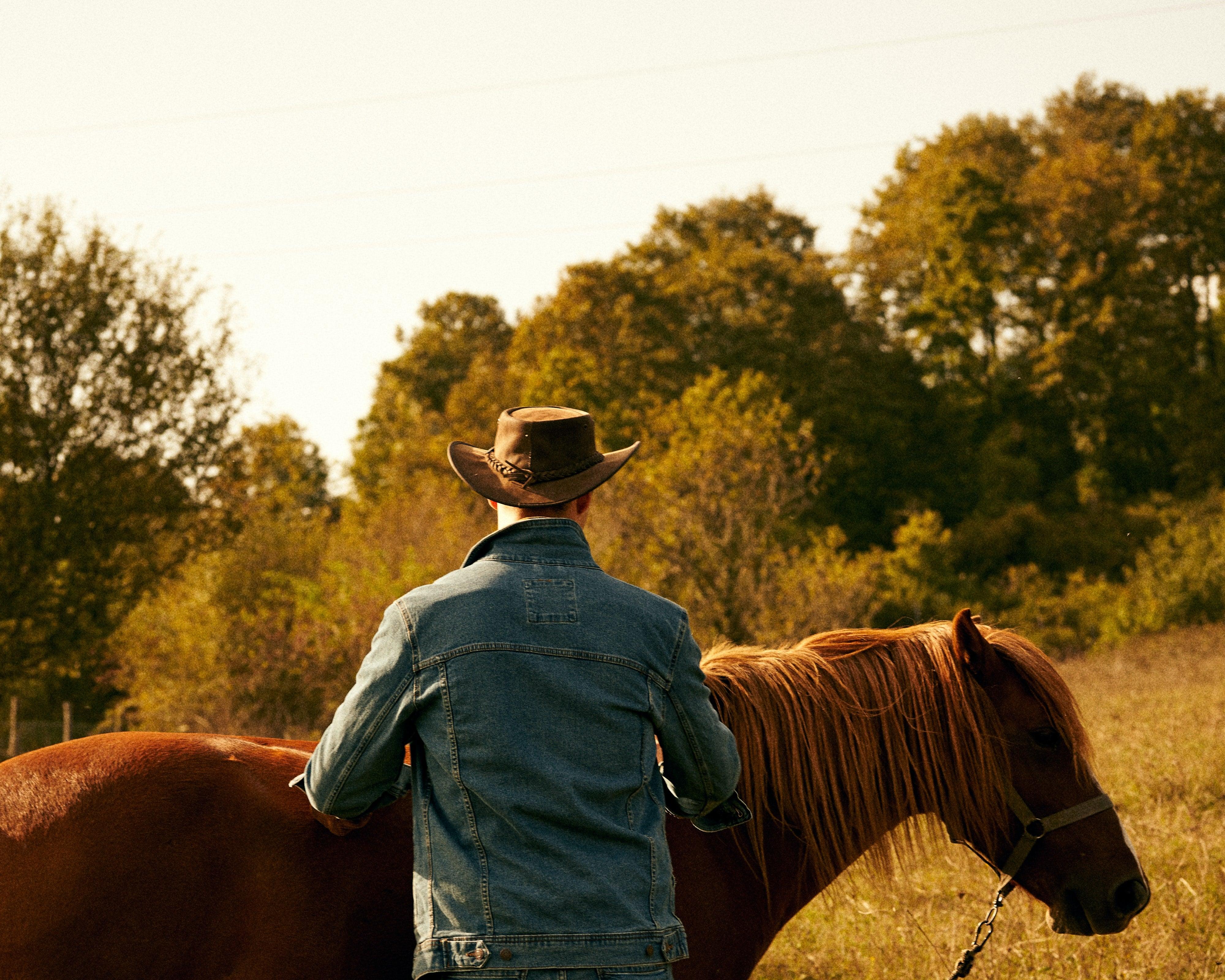 cowboy wearing a brown leather cowboy hat